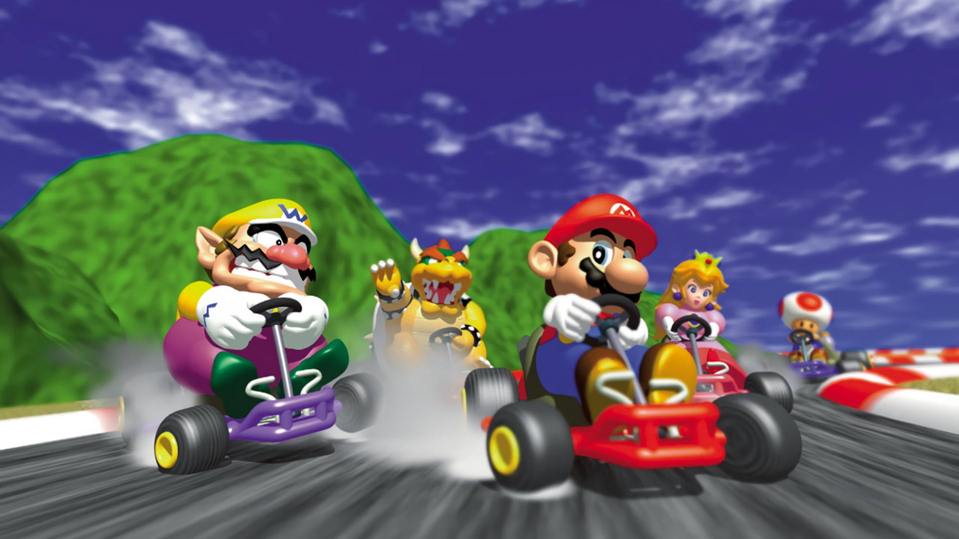 Mario Kart 64 racers speed around a bright Nintendo 64 track.
