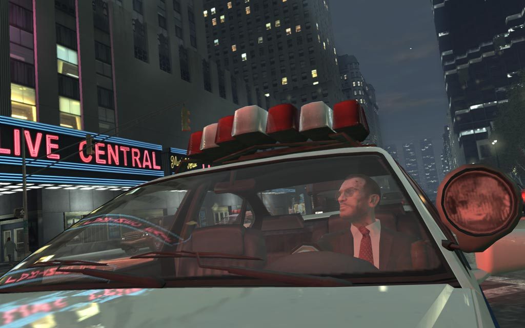 Niko Bellic riding through a neon-lit Liberty City theater district in Grand Theft Auto IV