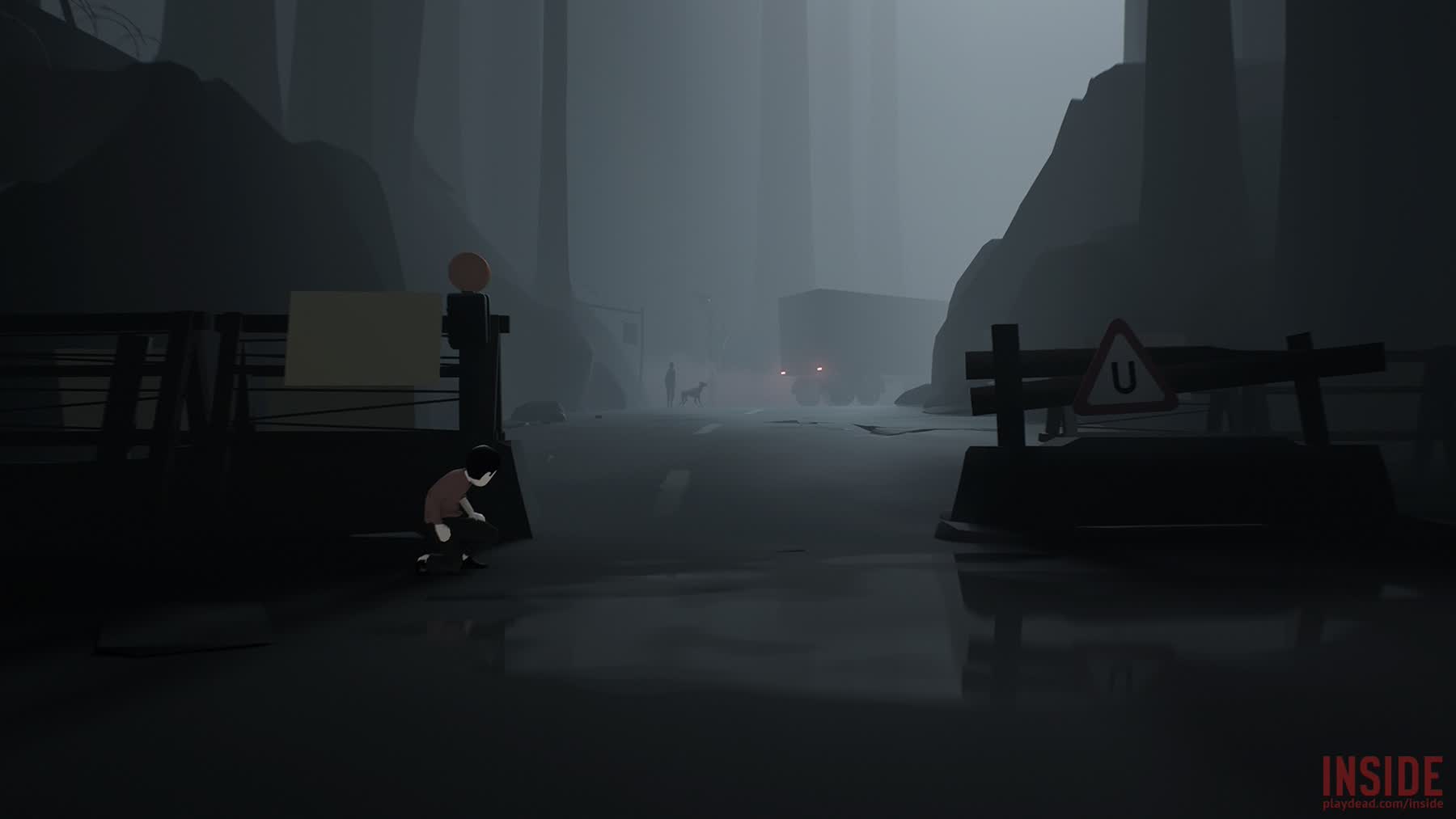 The boy hides near a roadblock in Inside