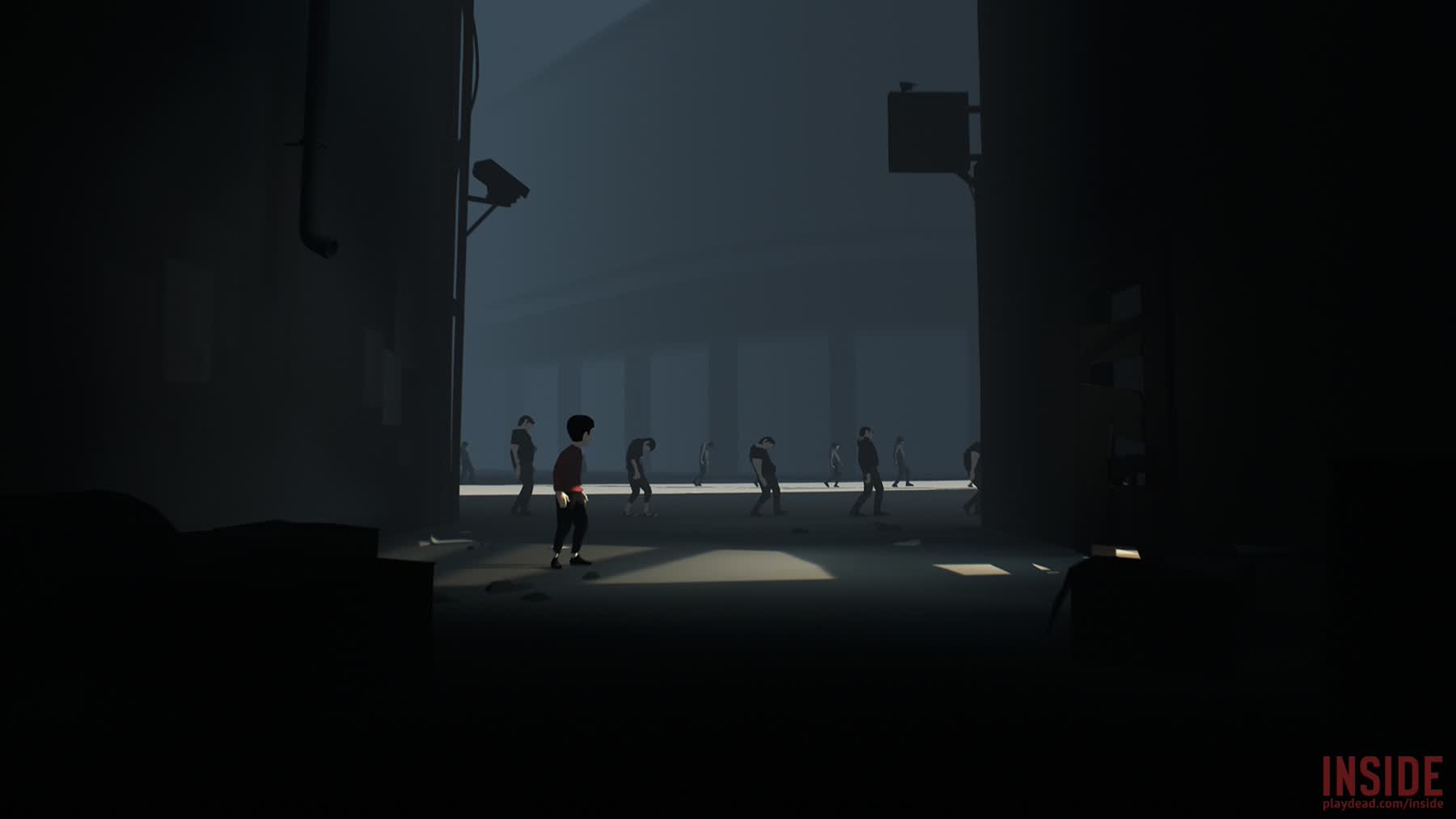 A line of figures move through a facility in Inside