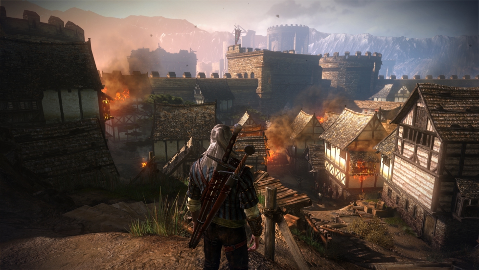 Geralt looks over burning fortifications in The Witcher 2: Assassins of Kings.