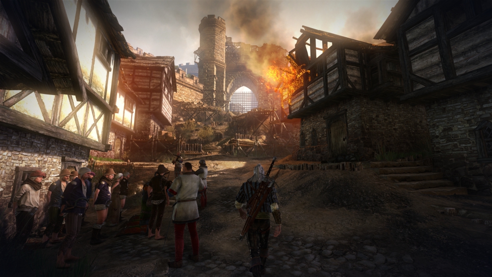 Geralt walks through a siege-torn town in The Witcher 2: Assassins of Kings.